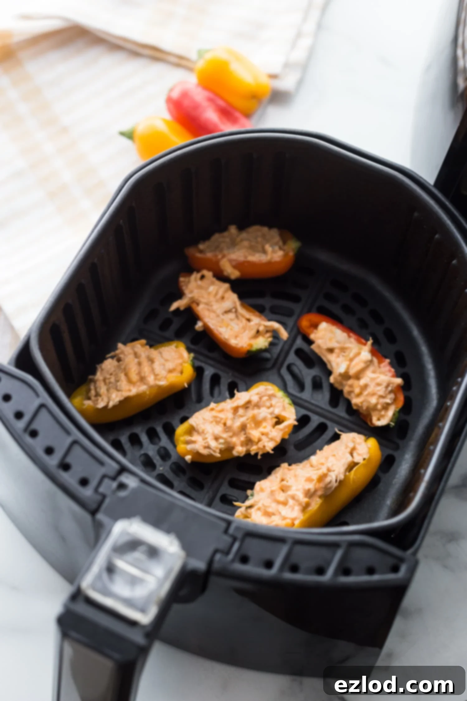 Fiery Buffalo Chicken Stuffed Peppers 9 Healthy Buffalo Chicken Stuffed Peppers nestled perfectly in an air fryer basket, ready to be cooked to perfection.