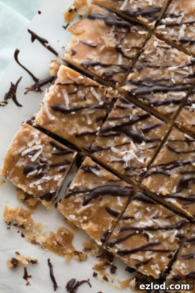 Overhead shot of a full batch of Healthy Samoas Cookie Bars, neatly cut into squares and arranged on a sheet of parchment paper, ready to be enjoyed.
