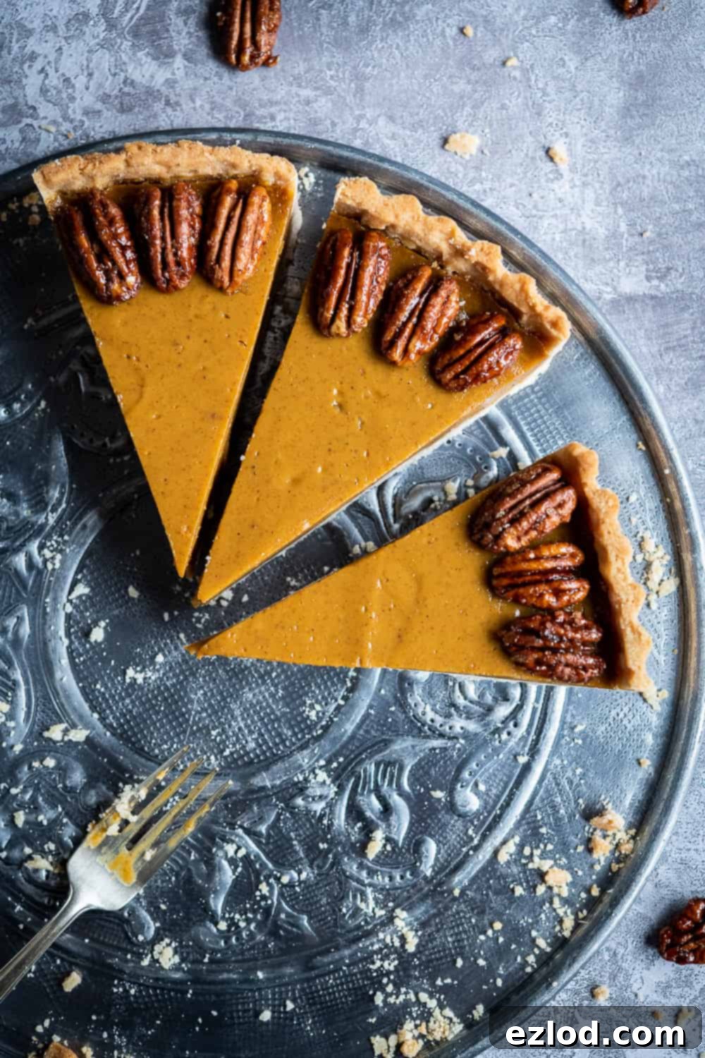 Three slices of the decadent vegan pumpkin pie, perfectly cut and ready to be served, showcasing the rich filling and flaky crust.
