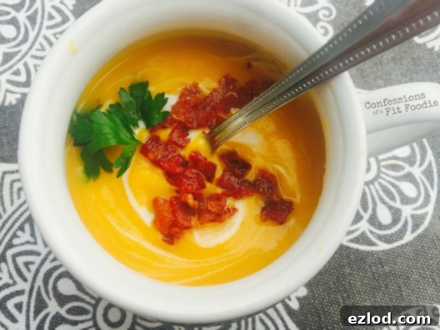 Smooth and creamy Butternut Squash Soup in a bowl, garnished with a swirl of cream.