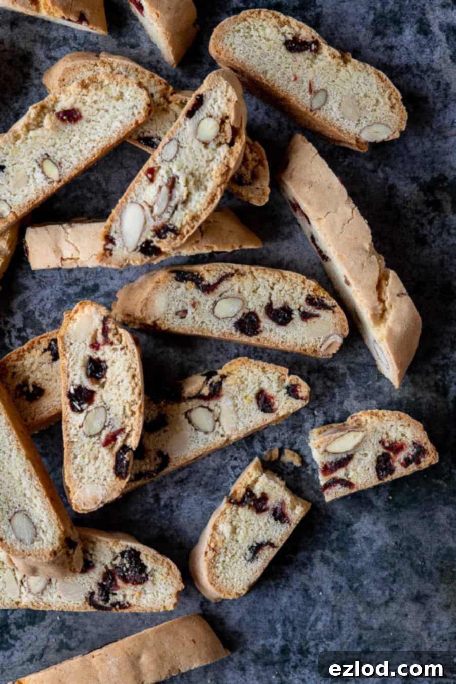 Vegan biscotti on a dark grey background, one broken in half.
