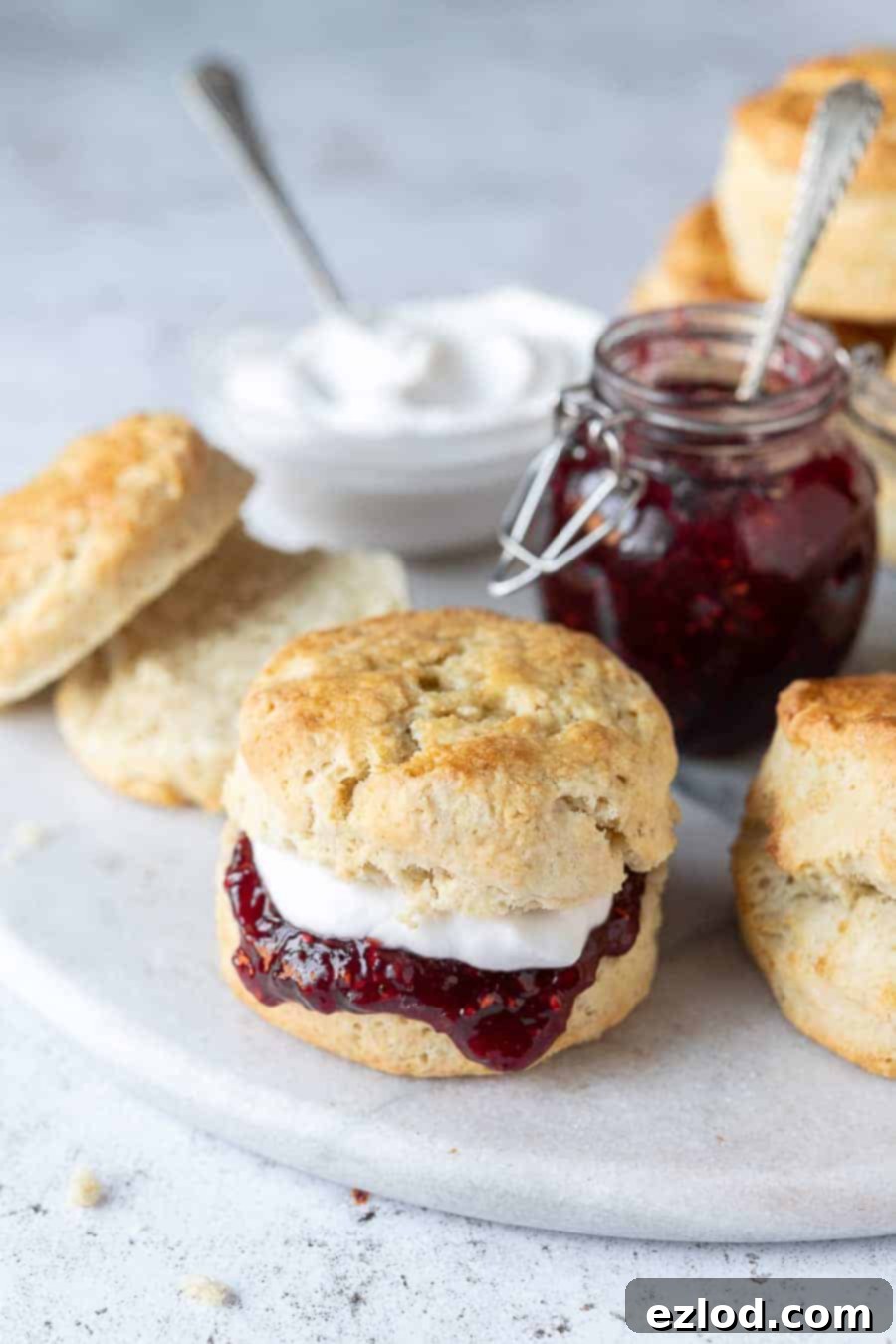 Close up of a vegan scone filled with raspberry jam and cream.