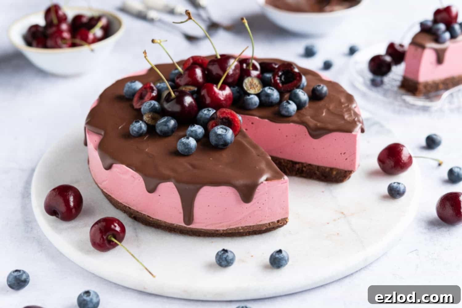 An elegant shot of the finished no-bake vegan chocolate cherry cheesecake on a smooth marble board, showcasing its perfectly set layers and glossy ganache.