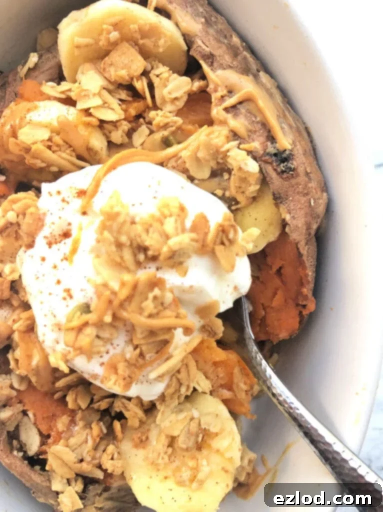 A close up of a sweet potato stuffed with bananas, granola and topped with plain Greek yogurt ready to serve as a sweet and savory snack