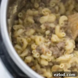 A serving of Healthy Homemade Hamburger Helper on a white plate, garnished with fresh parsley.