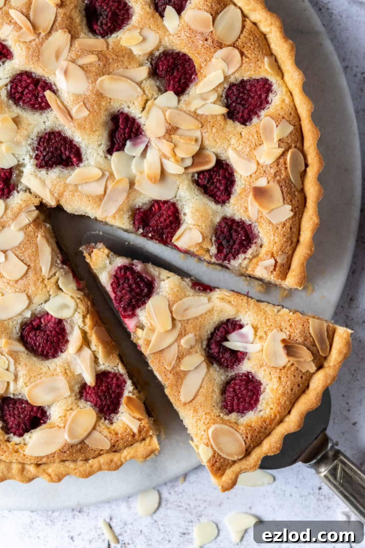 Close up of vegan Bakewell tart with a slice cut out.