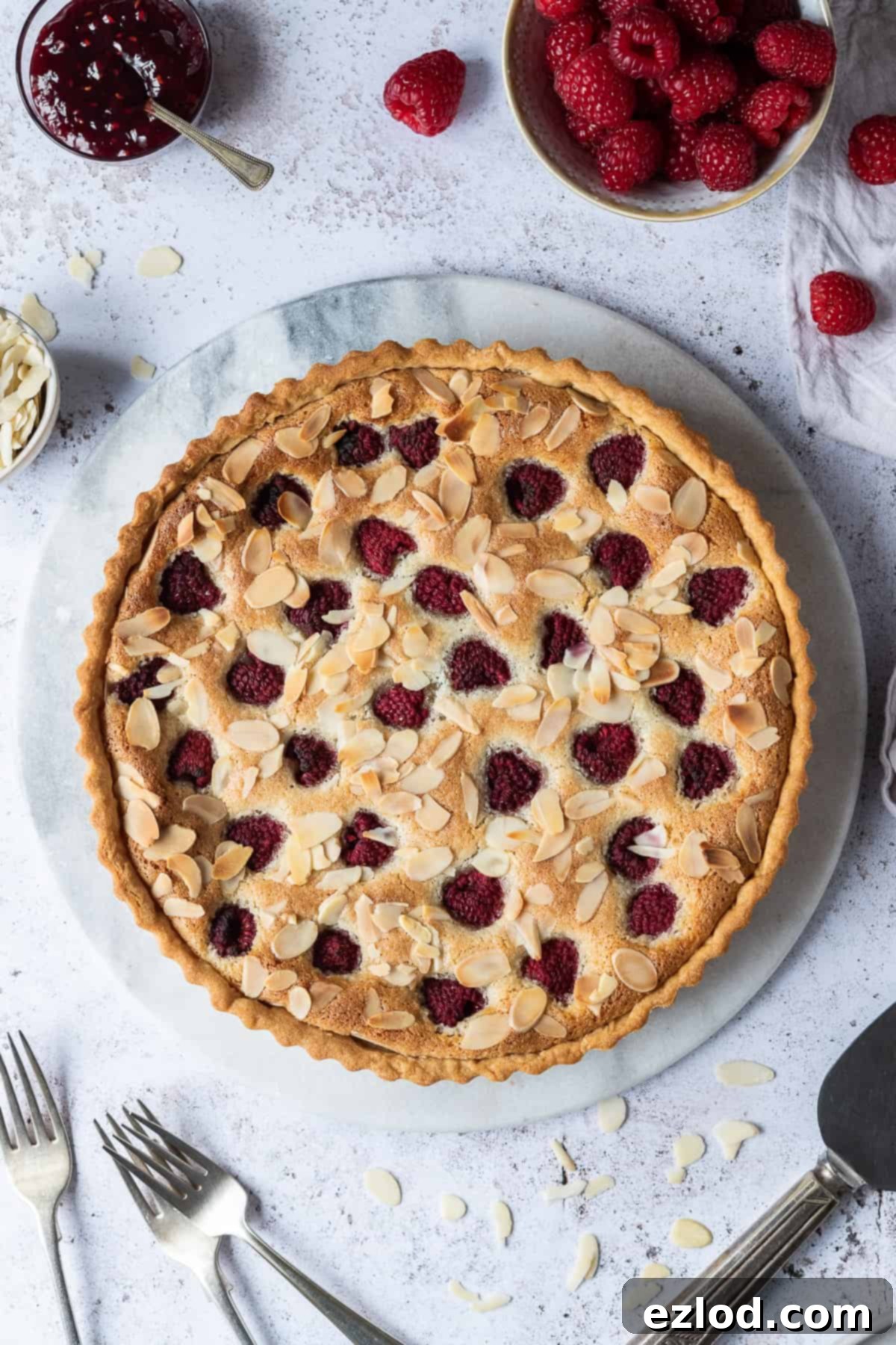 Vegan Bakewell tart on a marble board on a white background.