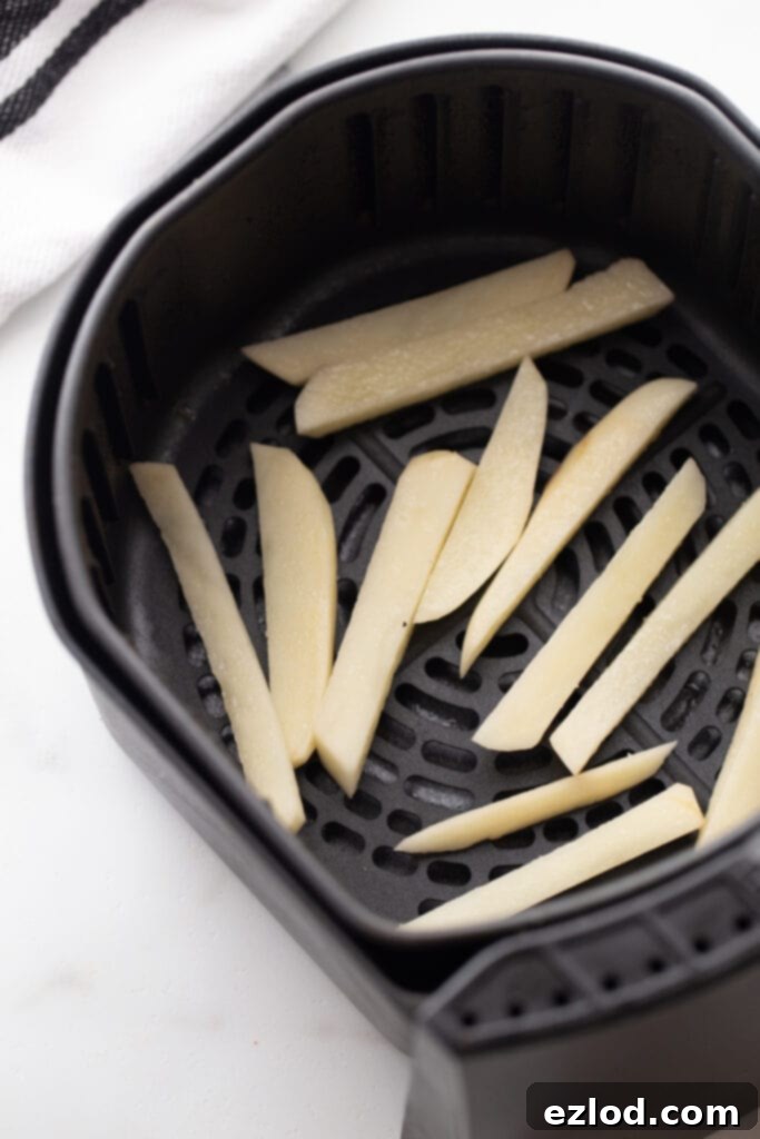 Overhead photo of an air fryer basket ready cook the homemade French fries