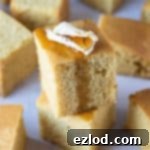 A stack of two squares of easy vegan cornbread topped with butter and maple syrup
