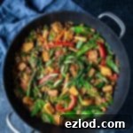 vegetable peanut fried rice in a black wok on a black background with a grey cloth.