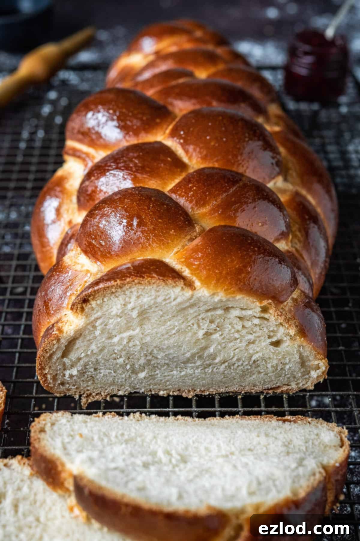 Close-up artistic shot of a rustic loaf of vegan challah, emphasizing its rich golden crust and intricate braided texture, ready to be enjoyed.