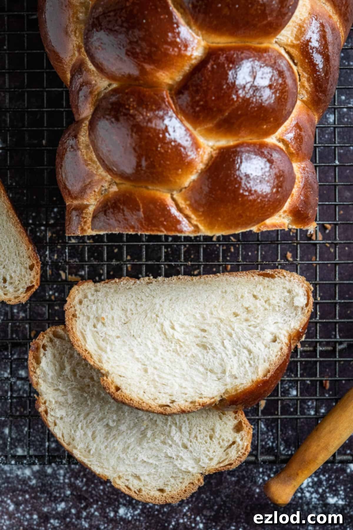 Close-up shot of a single slice of homemade vegan challah bread, revealing its airy texture and golden-brown crust, emphasizing its inviting softness.