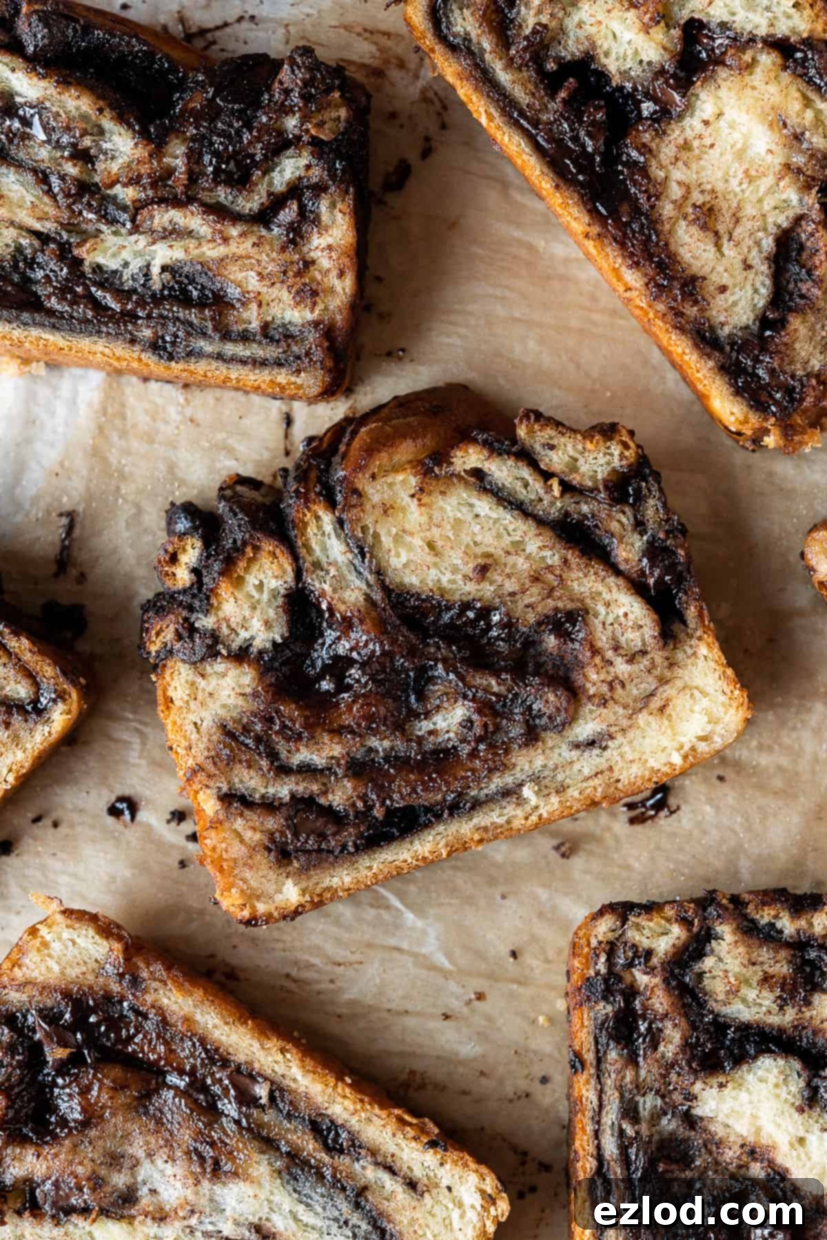 A close-up shot of a single slice of vegan chocolate babka, highlighting the intricate swirls of chocolate and the soft, moist texture of the bread.