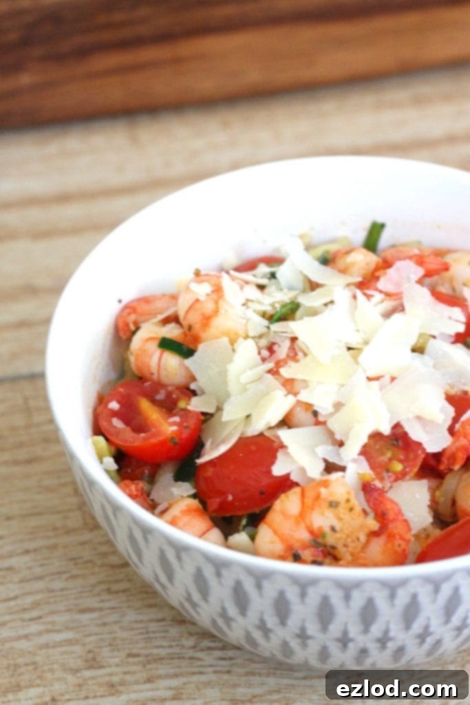 Bowl of shrimp and zucchini noodles topped with parmesan