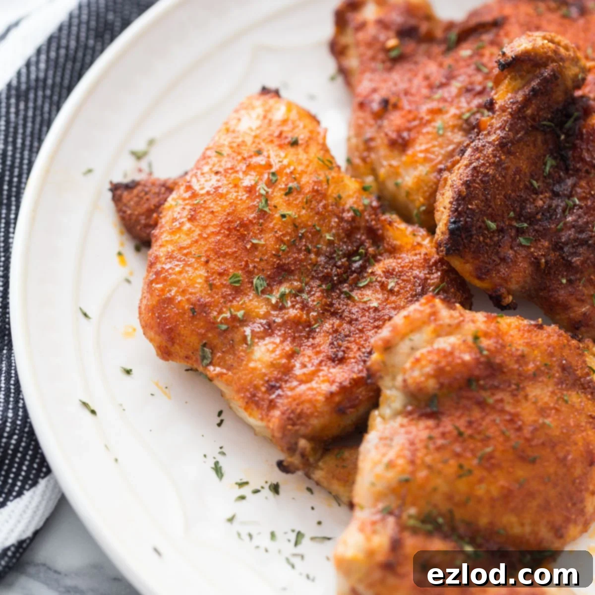 Effortless Crispy Chicken Thighs 2 A plate of Boneless Skinless Air Fryer Chicken Thighs with fresh and dried herbs and spices.