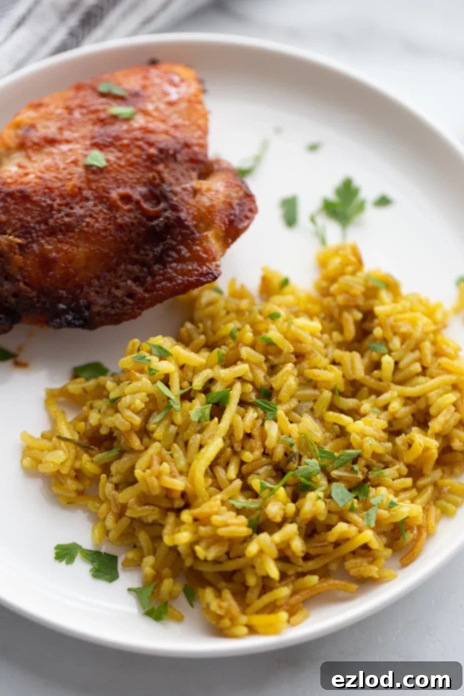 Effortless Crispy Chicken Thighs 6 Plate of homemade rice a roni and cooked chicken thighs.