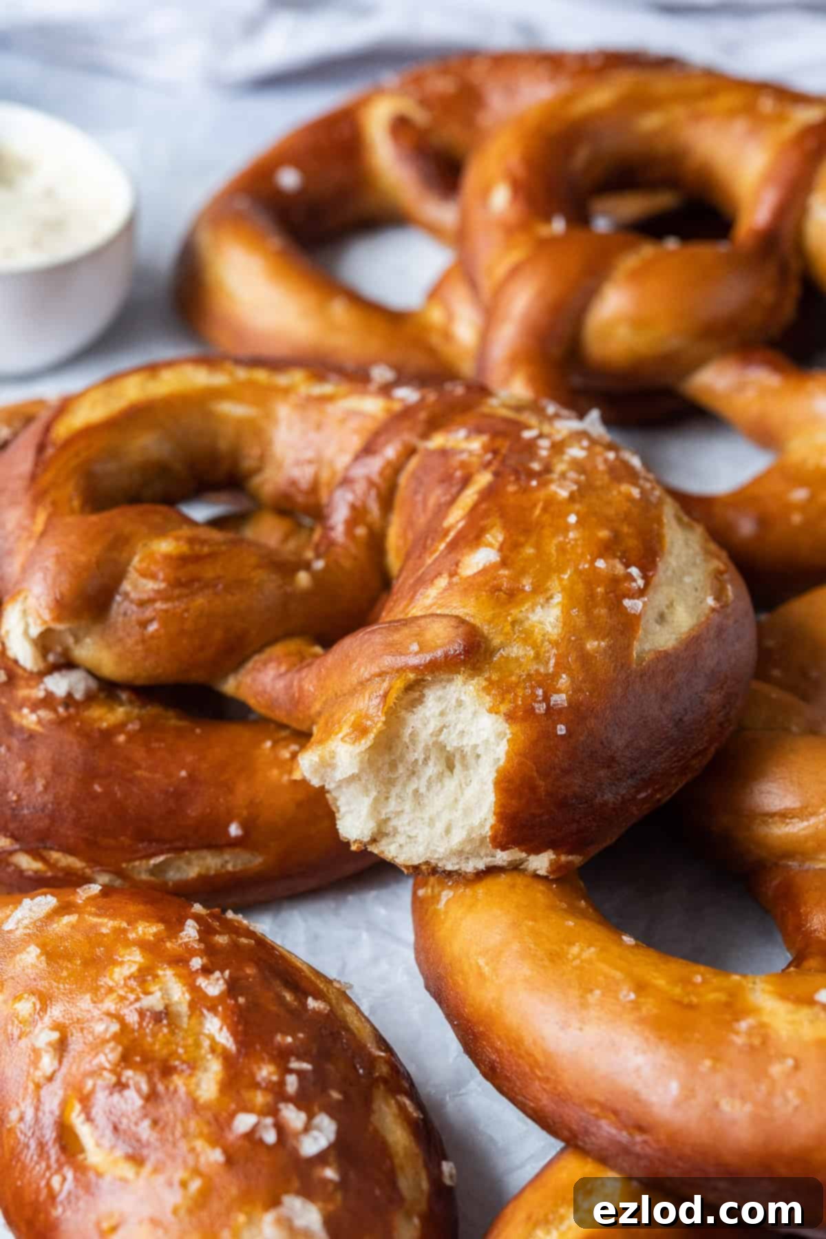 Close-up internal view of a baked vegan pretzel, revealing its soft, airy crumb texture with a golden crust.