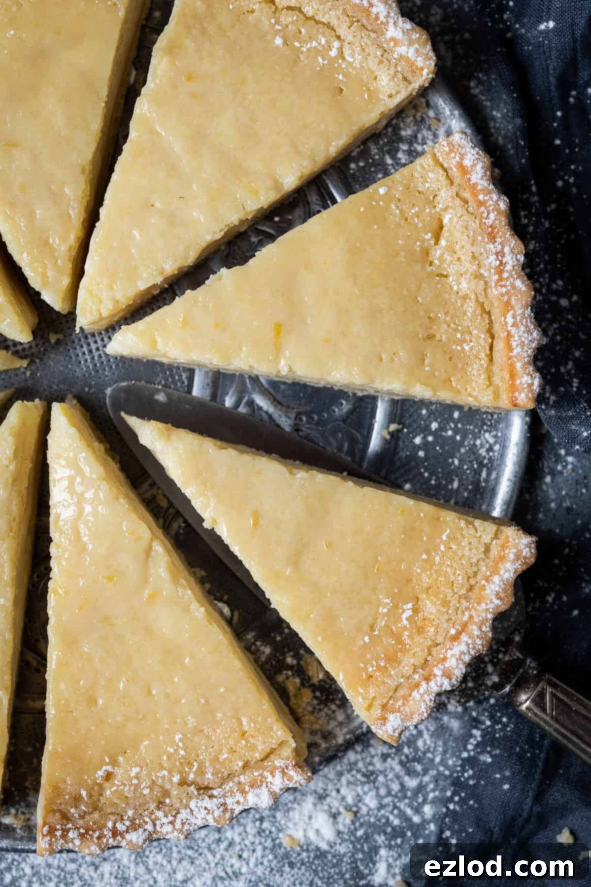 Slices of vegan lemon tart on a metal plate, ready for serving.