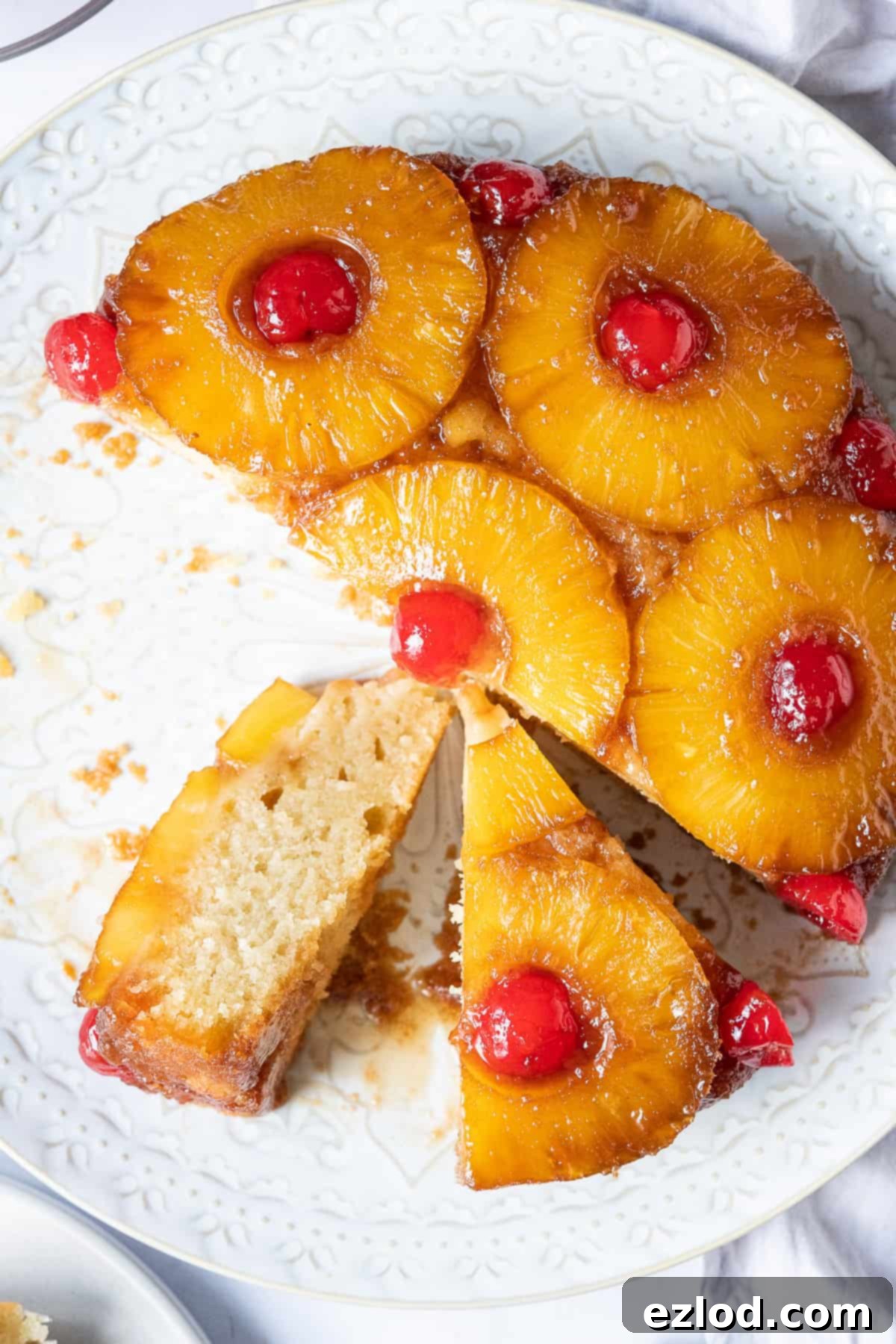 A close-up view of vegan pineapple upside-down cake, beautifully cut into individual slices, showcasing the caramelized pineapple and moist cake texture.