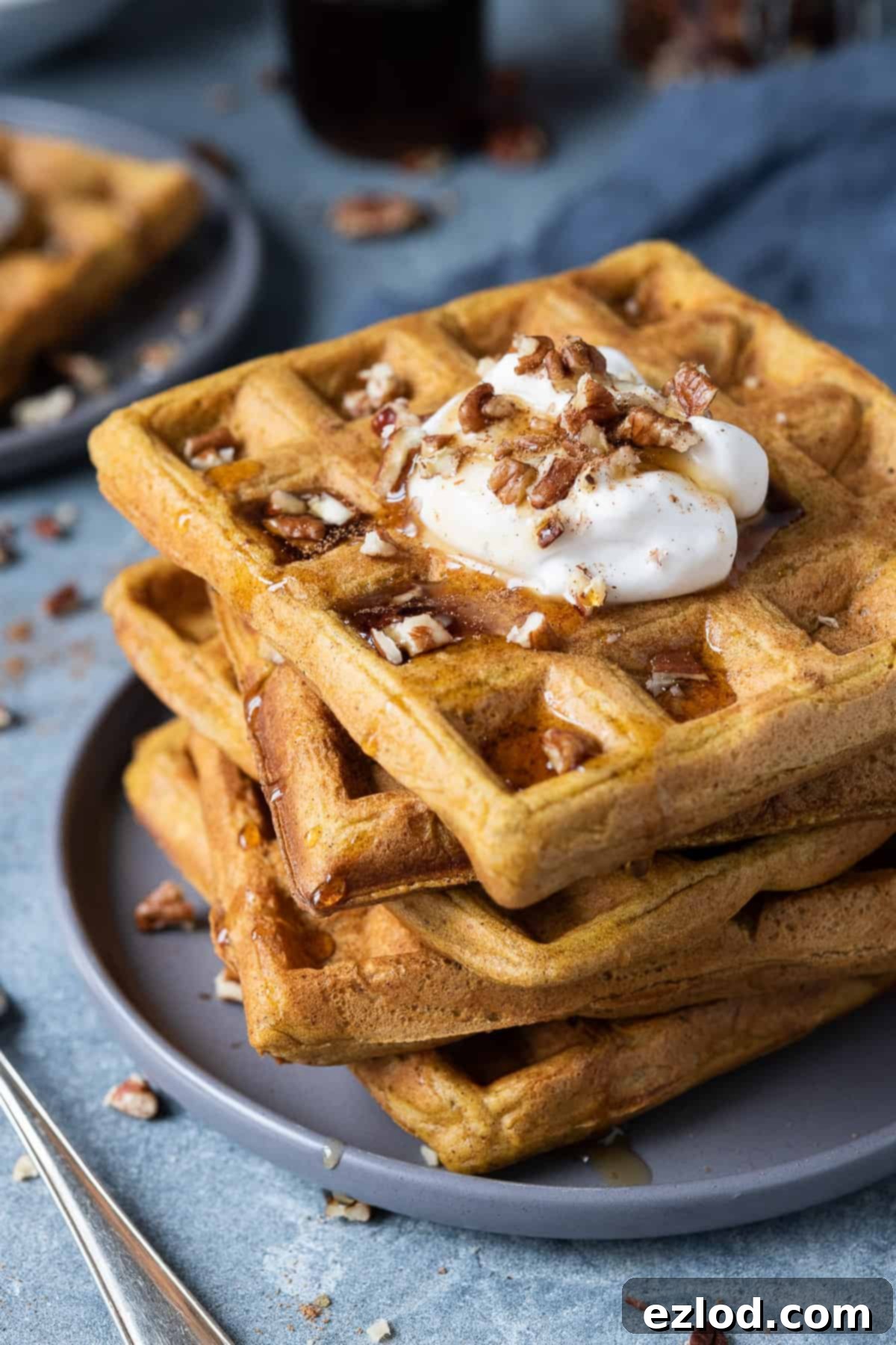 A stack of vegan pumpkin waffles on a grey plate.