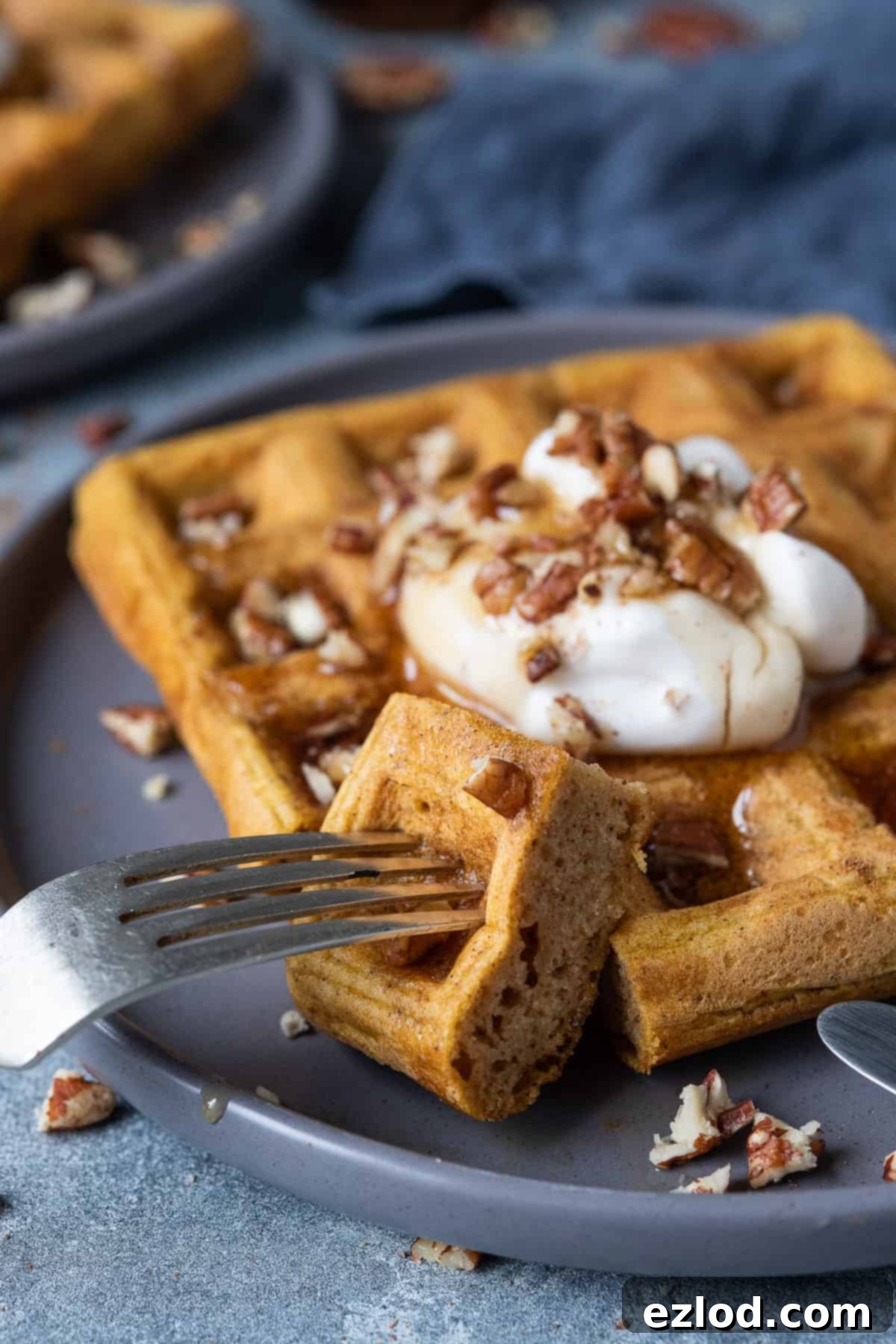 Close up of a forkful of vegan pumpkin waffle showing its fluffy interior.