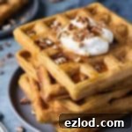 A stack of vegan pumpkin waffles on a grey plate.