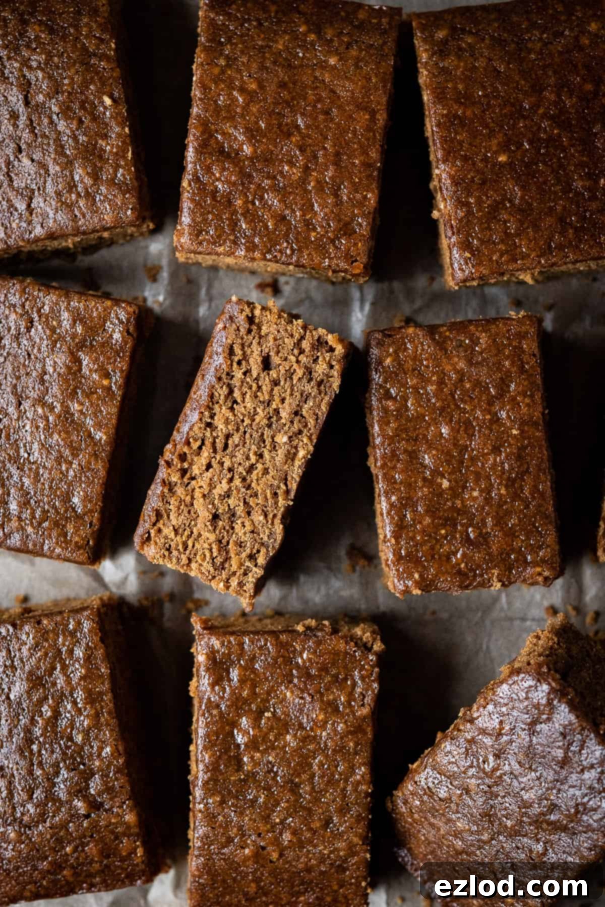 A vibrant close-up of multiple squares of vegan parkin, showing their dense, moist, and sticky texture, inviting the viewer to enjoy.