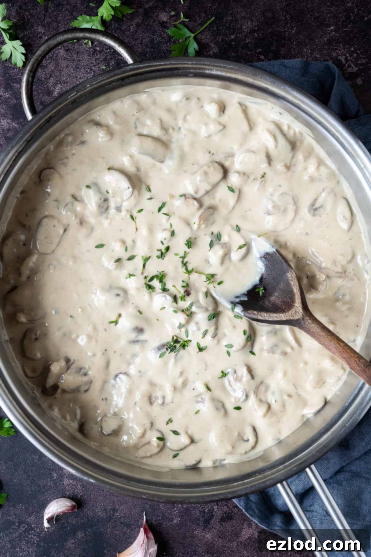 A pan of vegan creamy mushroom sauce on a dark background.
