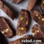 Vegan chocolate pistachio biscotti on a sheet of white baking parchment.