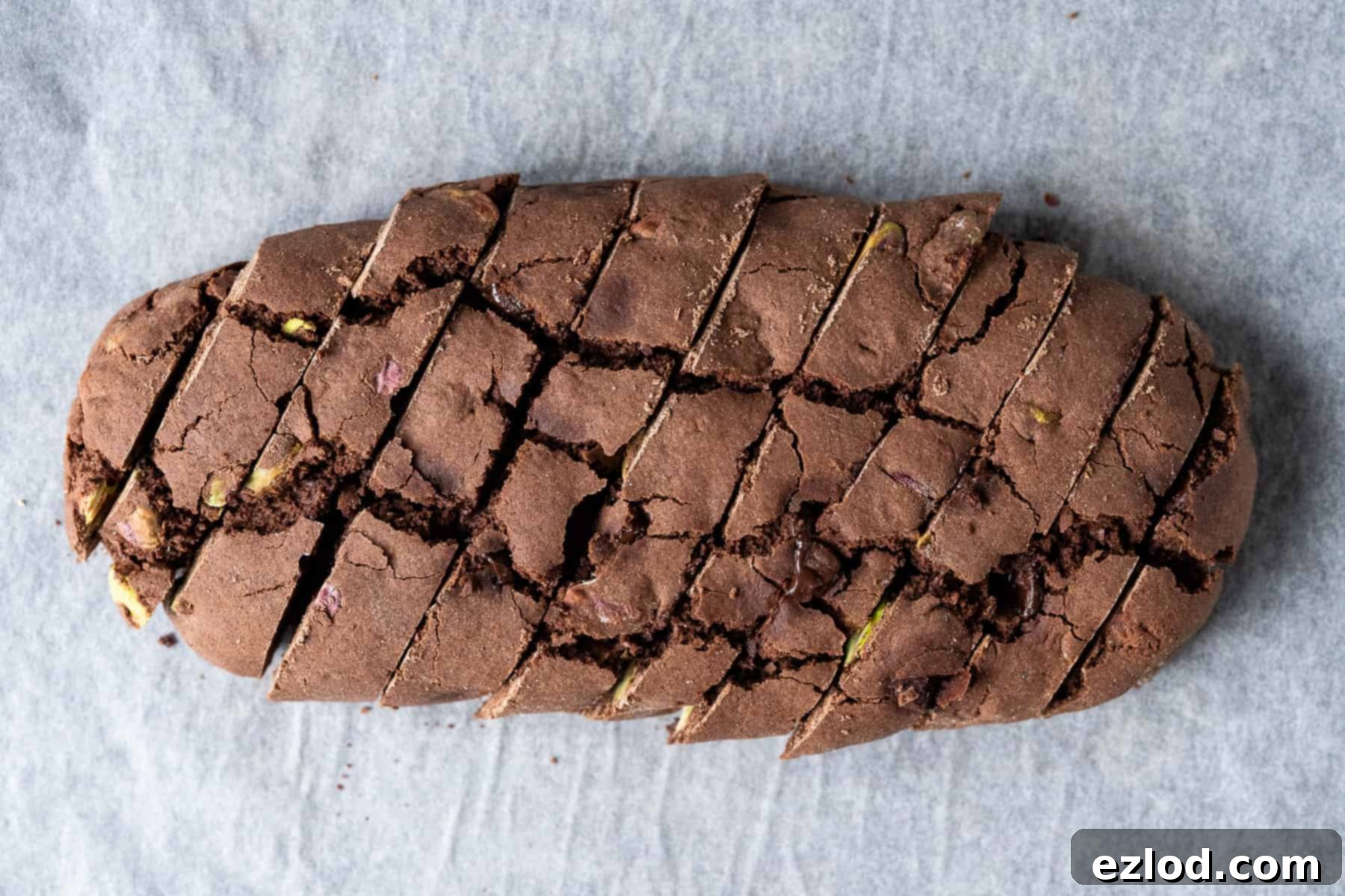 Step 4: Demonstrating the slicing of the cooled biscotti logs into individual diagonal pieces with a serrated knife.
