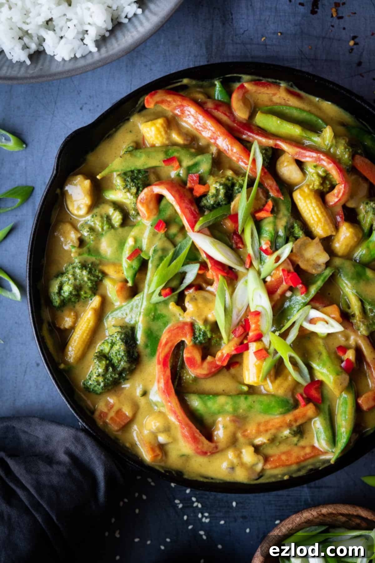 A close-up view of a pan filled with rich, golden vegan Chinese vegetable curry, showcasing the vibrant colors and inviting texture of the sauce and vegetables.