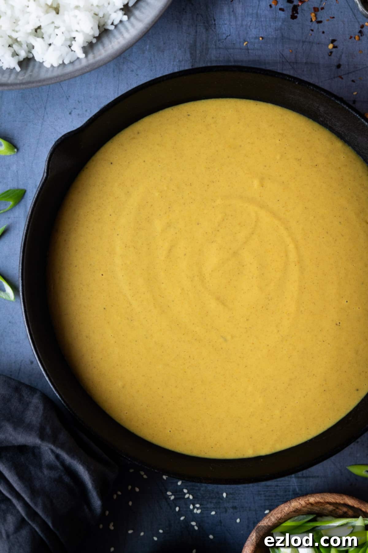 Close-up of the rich, golden vegan Chinese curry sauce resting in a black pan, ready to be served, highlighting its smooth, creamy texture.