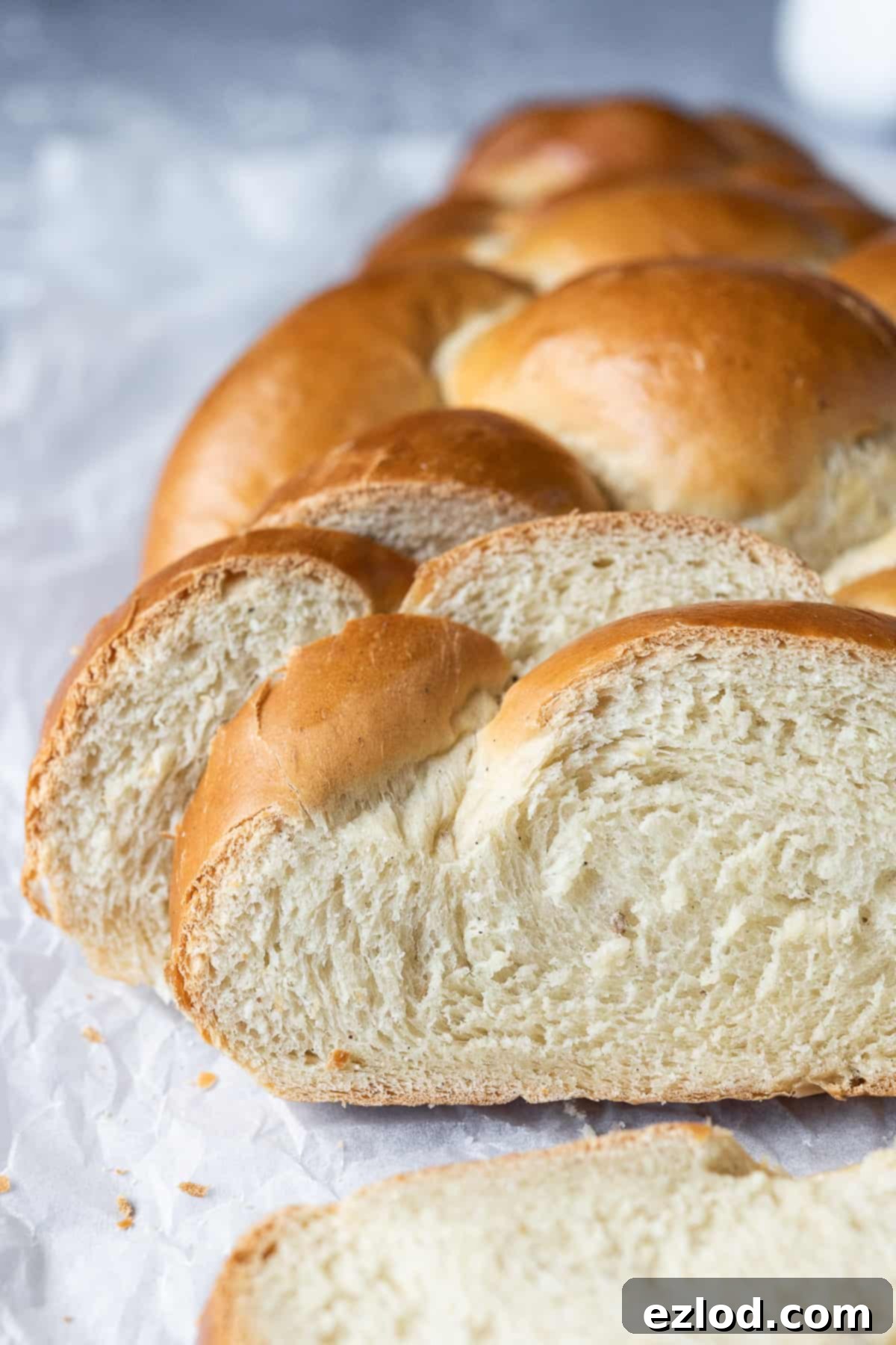 A close-up view of a perfectly sliced vegan pulla loaf, revealing its soft, airy crumb and the subtle specks of cardamom, inviting a delicious taste.