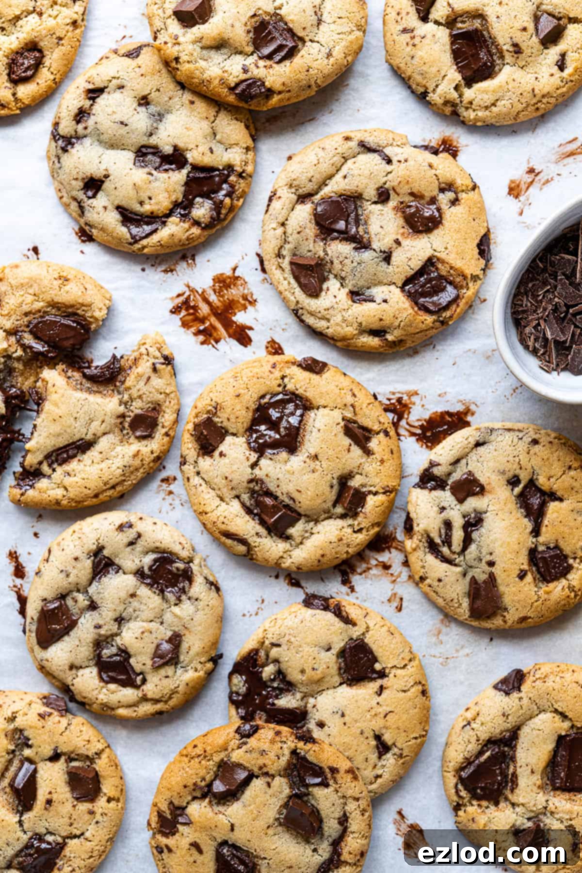 Olive oil chocolate chip cookies on a sheet of white baking parchment.