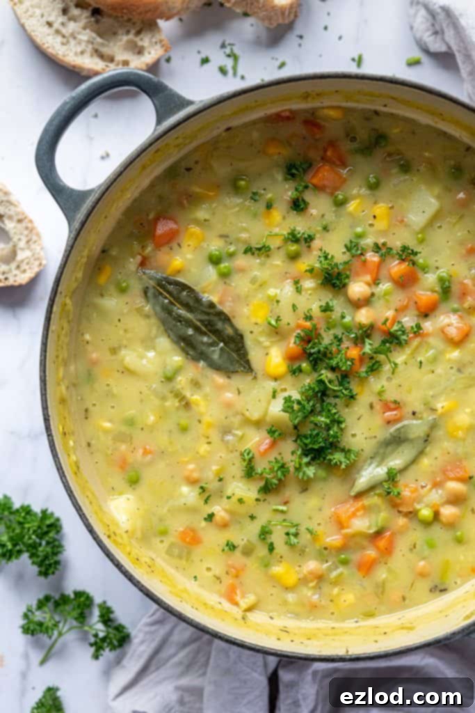 A close-up view of the rich and creamy vegetable chickpea soup simmering in a pan, showcasing its hearty texture and vibrant ingredients.