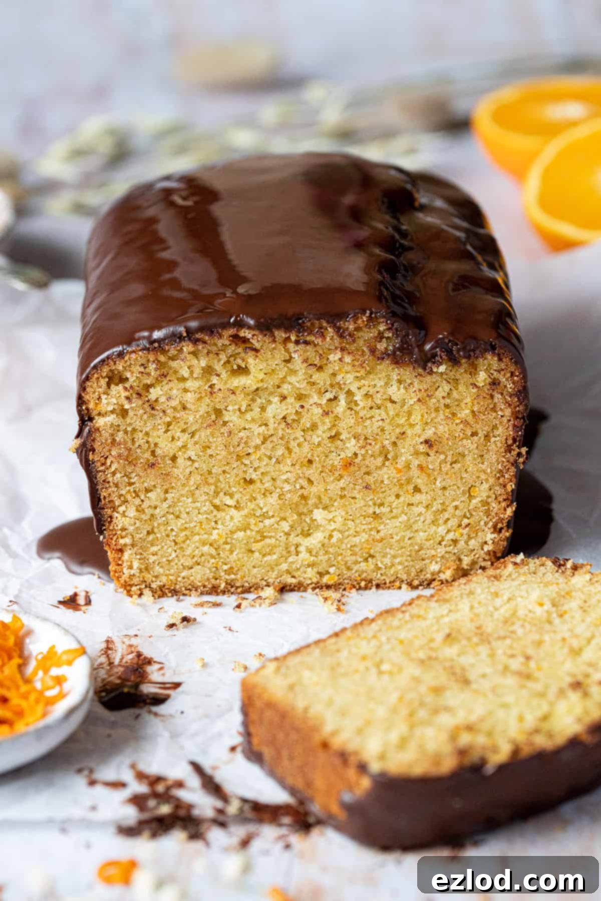 A close-up view of a perfectly sliced vegan orange loaf cake, revealing its moist and tender crumb texture.