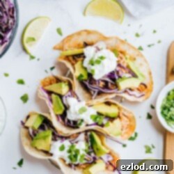 Ultimate Instant Pot Chicken Tacos 5 Three perfectly assembled Instant Pot chicken tacos are garnished with fresh cilantro and a dollop of Greek yogurt, showcasing a tempting presentation.