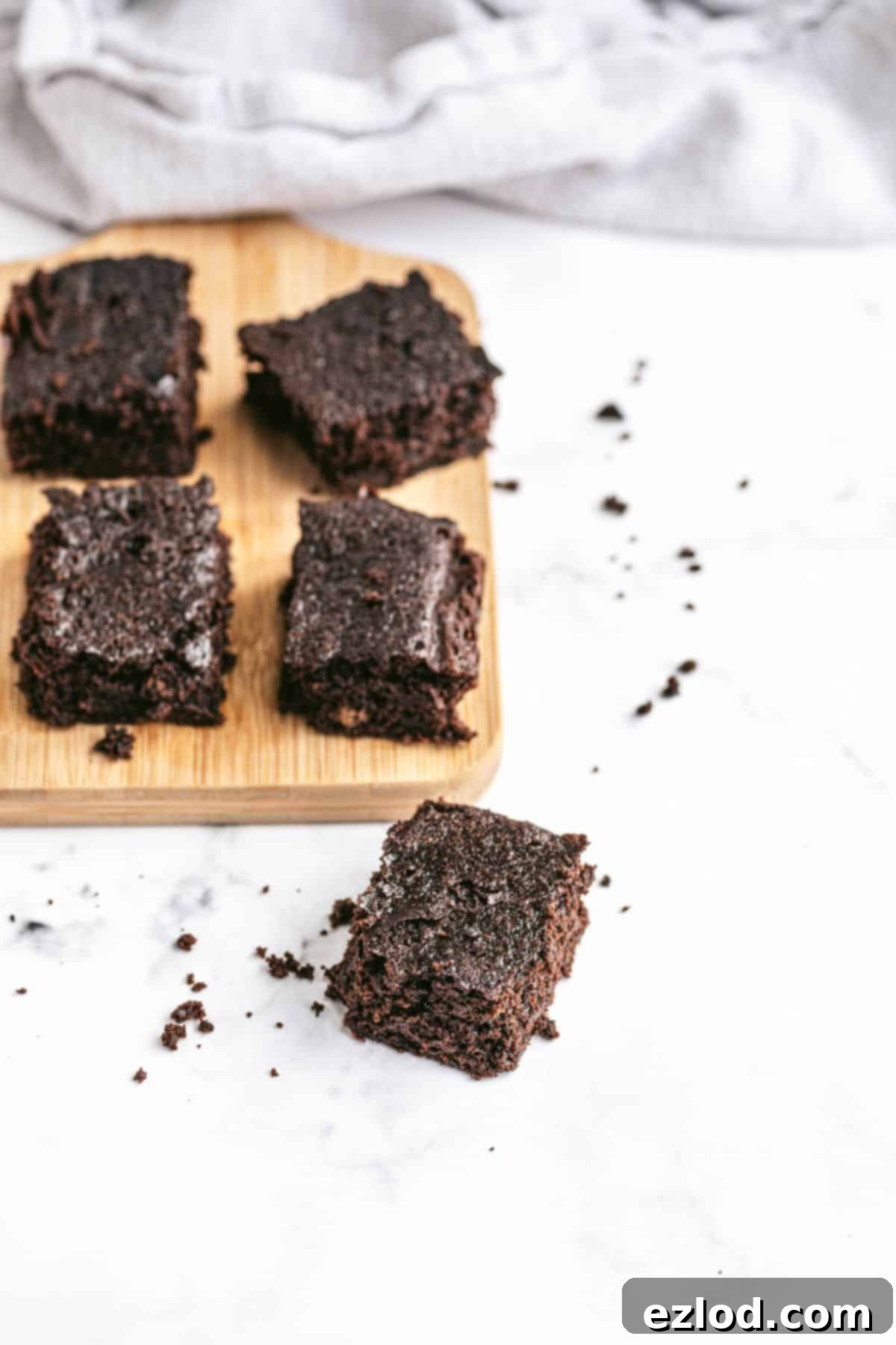 Healthy brownies on a rustic wooden cutting board, ready to be served.