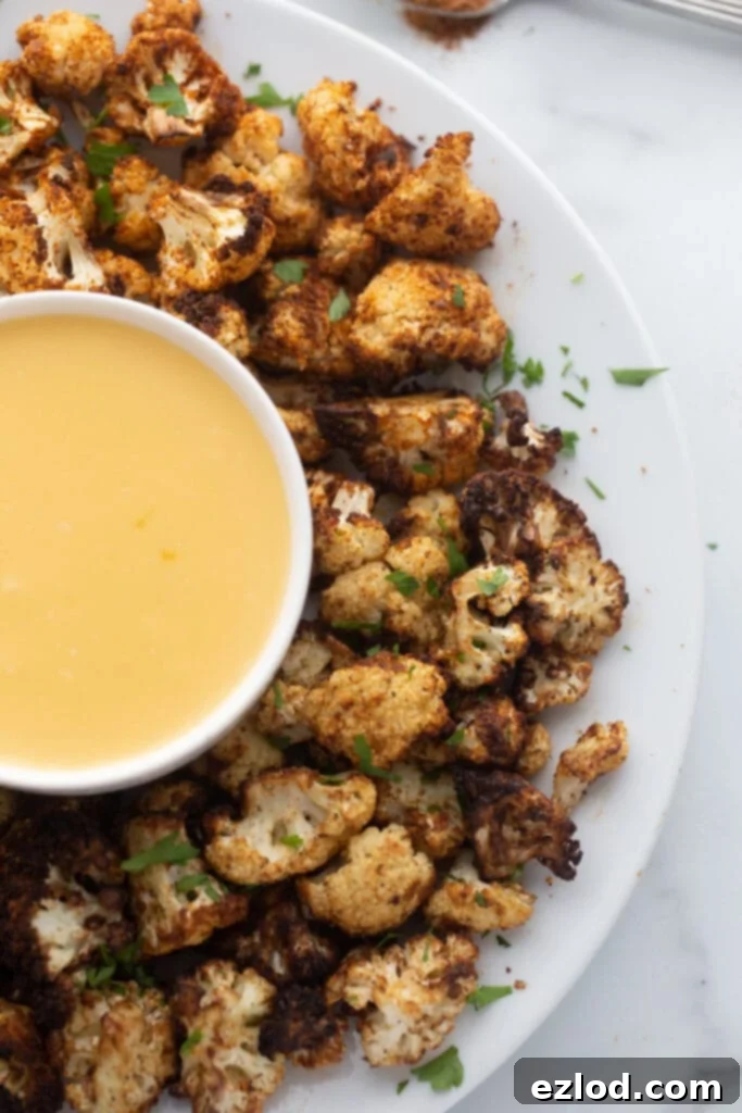 Overhead image: seasoned cauliflower with homemade cheese sauce on a platter
