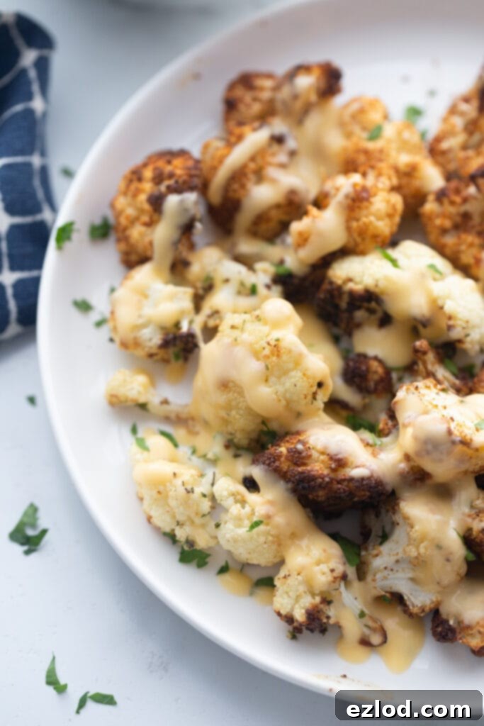 A plate of Crispy air fryer cauliflower drizzled with homemade cheese sauce