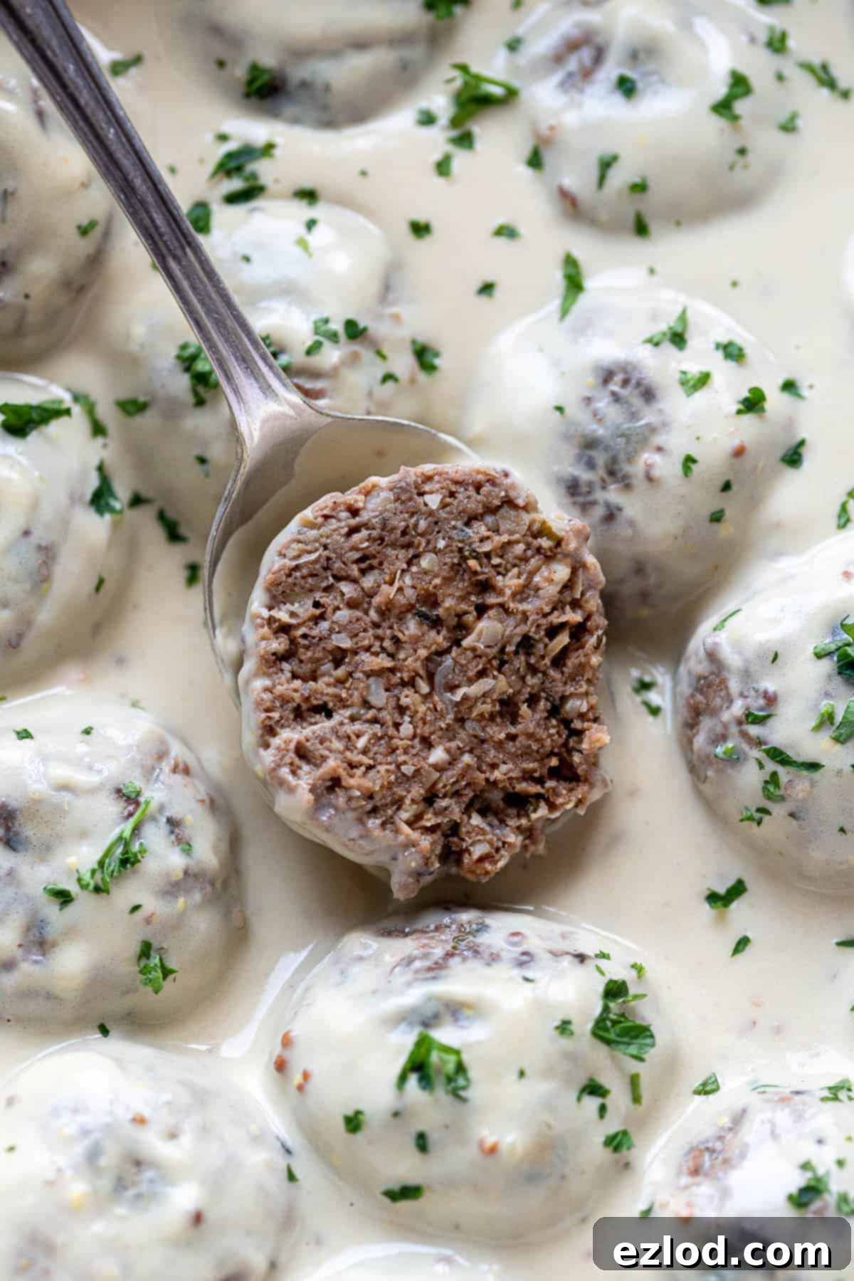 Close up of a meatball that has been sliced in half.