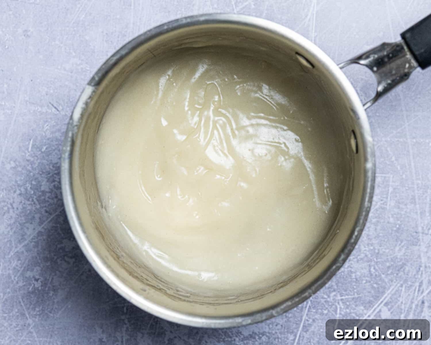 Close-up of the perfectly cooked tangzhong mixture in a saucepan, resembling a thick, smooth paste, ready for the next step.