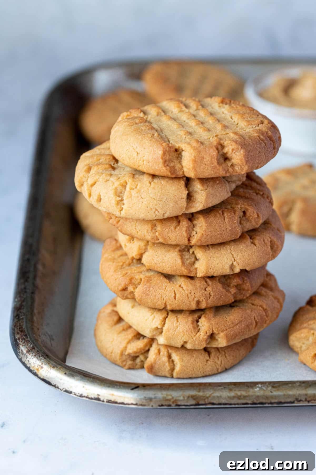 A perfectly baked stack of five vegan peanut butter cookies, showcasing their golden-brown color and inviting texture.