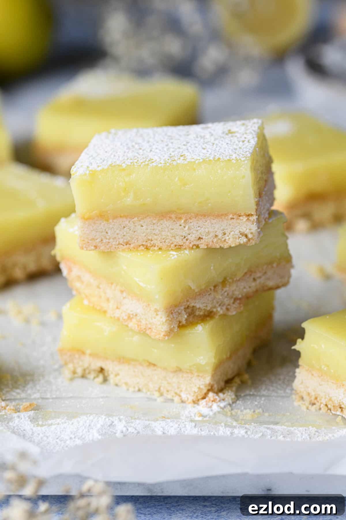 A stack of golden-yellow vegan lemon bars with a crisp shortbread base, ready to be enjoyed.