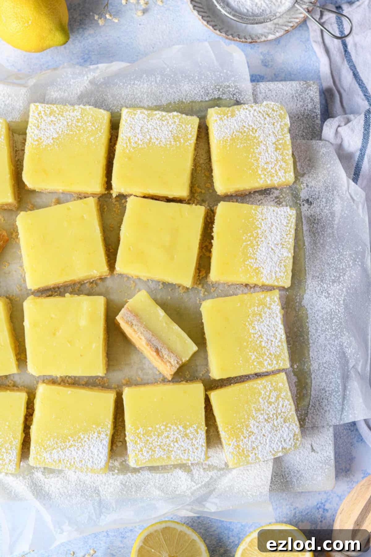 A close-up view of a perfectly sliced vegan lemon bar, showcasing its distinct layers of golden shortbread and creamy lemon curd.