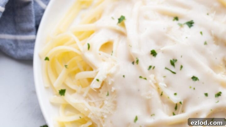Creamy and light Healthy Alfredo Sauce over pasta.