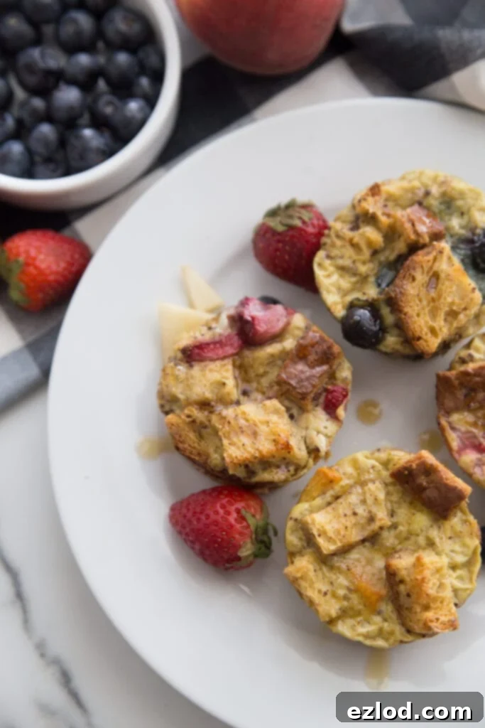 Healthy French Toast Casserole Cups on a white plate topped with different fresh fruit 