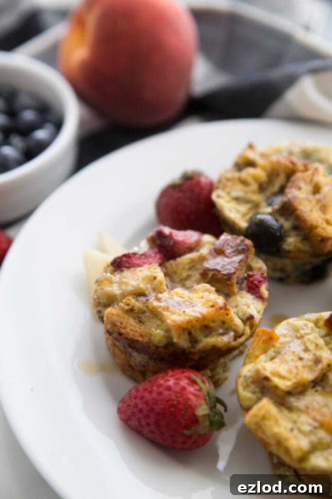 A close up of mini french toast casserole cups on a round white plate garnished wit berries 
