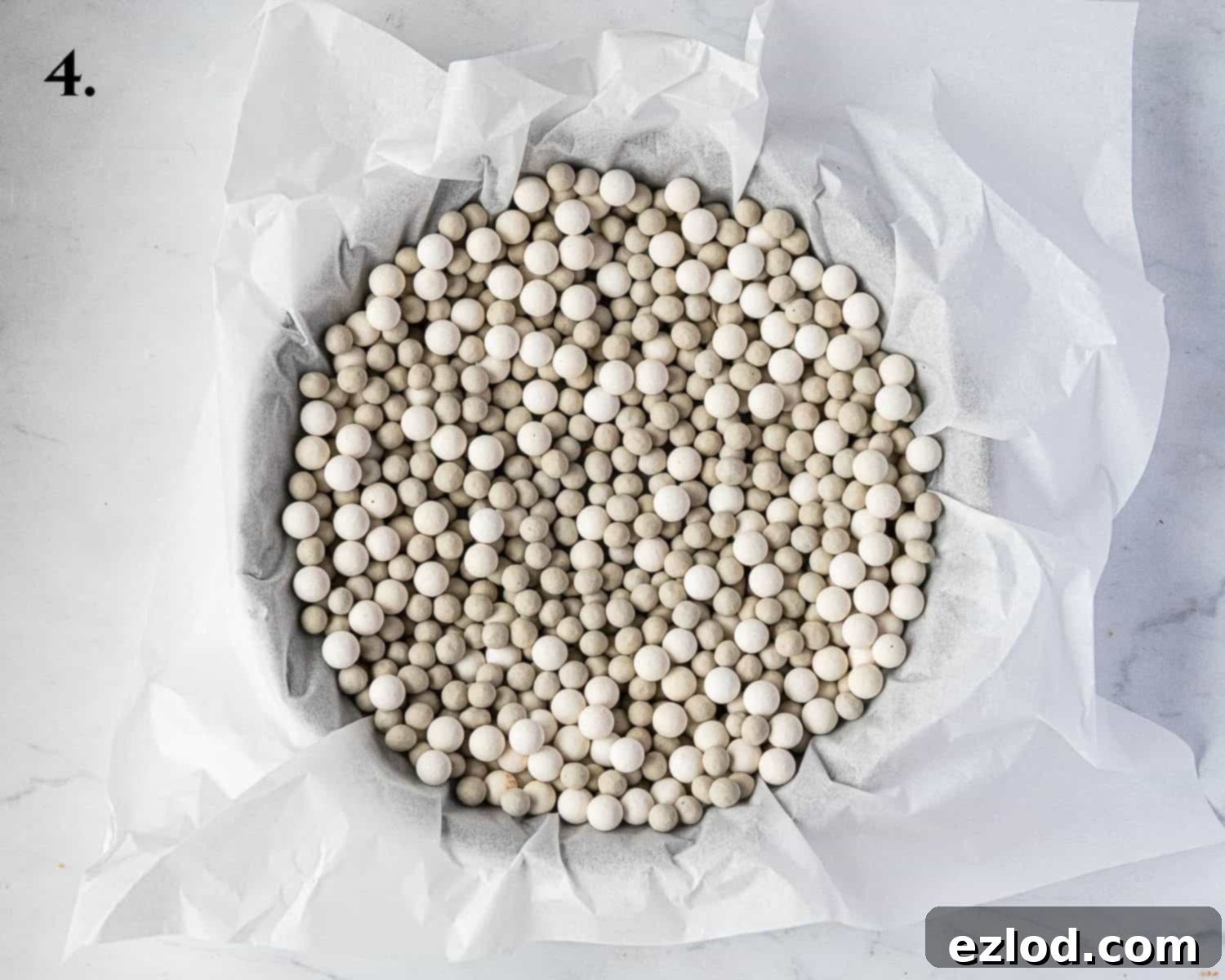 Step 4 in making chocolate strawberry tart: The chocolate pastry case lined with baking parchment and filled with baking beans, prepared for blind baking.