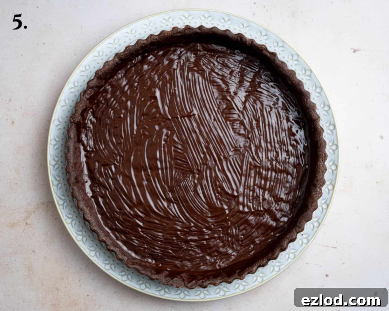 Step 5 in making chocolate strawberry tart: The fully baked chocolate pastry case with its interior brushed with a layer of melted dark chocolate, forming a moisture barrier.